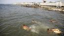 Anak-anak berenang di kawasan Cilincing, Jakarta, Selasa (2/8/2021). Lembaga Antariksa Amerika Serikat (NASA) memperkirakan wilayah Jakarta bagian Utara akan tenggelam akibat kenaikan permukaan air laut imbas pemanasan global dan pencairan lapisan es. (Liputan6.com/Faizal Fanani)