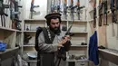Seorang pedagang senjata Hakimullah Afridi memamerkan senapan otomatis buatan lokal di tokonya, Darra Adamkhel, Pakistan, 14 Desember 2022. Kota Darra Adamkhel telah lama dikenal dengan bazar pasar gelap senjatanya. (Abdul MAJEED/AFP)