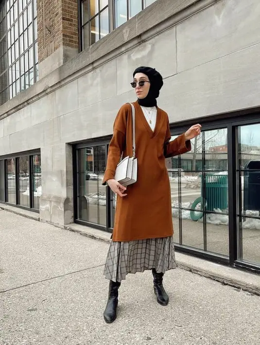 Padukan tunik panjang warna brick dengan plaid skirt. Gunakan sock boots warna hitam dan tambahkan aksesori berupa topi baret. Dijamin lookmu makin kece! (Instagram/elifd0gan).