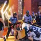 Polisi menyemprot demonstran dengan merica saat unjuk rasa atas kematian George Floyd oleh polisi di luar Third Police Precinct, Minneapolis, Minnesota, Amerika Serikat, Rabu (27/5/2020). Ribuan warga kulit hitam turun ke jalan menuntut polisi mengusut tuntas kasus tersebut. (Kerem Yucel/AFP)