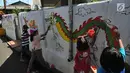 Sejumlah anak melukis mural pada dinding areal gang sempit saat kegiatan kick off Kampung Mural di Pulo Gelis, Bogor, Minggu (18/3). Kegiatan membuat mural dengan berbagai tema ini diikuti sejumlah komunitas dan warga setempat. (Merdeka.com/Arie Basuki)