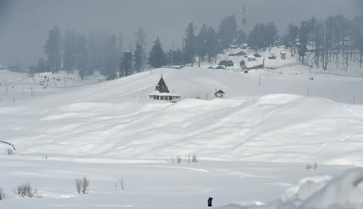 Orang-orang berjalan di resor ski di Gulmarg, sekitar 55 km utara Srinagar, Jammu dan Kashmir, India, 25 Januari 2021. Gulmarg mempunyai lansekap kawasan pedesaan dengan ladang-ladang gandum dan bunga warna-warni. (Tauseef MUSTAFA/AFP)