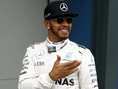 Pembalap Mercedes F1 Lewis Hamilton tersenyum usai kualifikasi di Australian Formula One Grand Prix di Melbourne (19/3). Lewis Hamilton menjadi yang tercepat pada sesi kualifikasi Formula 1 2016 di Sirkuit Albert Park. (REUTERS/Jason Reed)