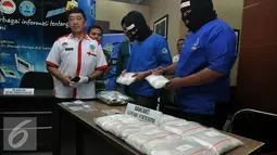 Dua orang tersangka penyelundupan narkotika asal Malaysia memperlihatkan barang bukti berupa sabu dan ekstasi, Jakarta, Rabu (17/6/2015). Tersangka yang merupakan ayah dan anak yaitu M (48), dan RMR (21) telah diamankan BNN. (Liputan6.com/Johan Tallo)