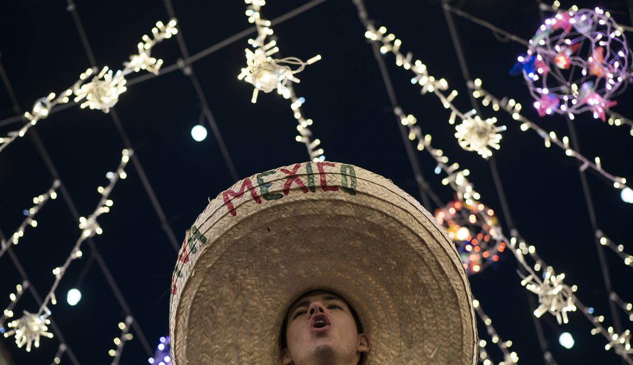 Suporter Meksiko memakai topi sombrero menyambut gelaran Piala Dunia di Jalan Nikolskava, Moskow, Rabu (13/6/2018). Piala Dunia 2018 akan berlangsung pada 14 Juni hingga 15 Juli mendatang. (AP/Felipe Dana)