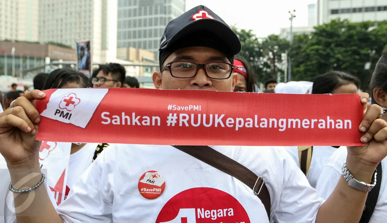 Seorang anggota PMI ikut serta dalam aksi di acara car free day, Bunderan HI, Jakarta, Minggu (6/3). Ratusan sukarelawan PMI meminta DPR untuk segera mengesahkan RUU Kepalangmerahan menjadi UU Kepalangmerahan pada tahun ini.(Liputan6.com/Yoppy Renato)