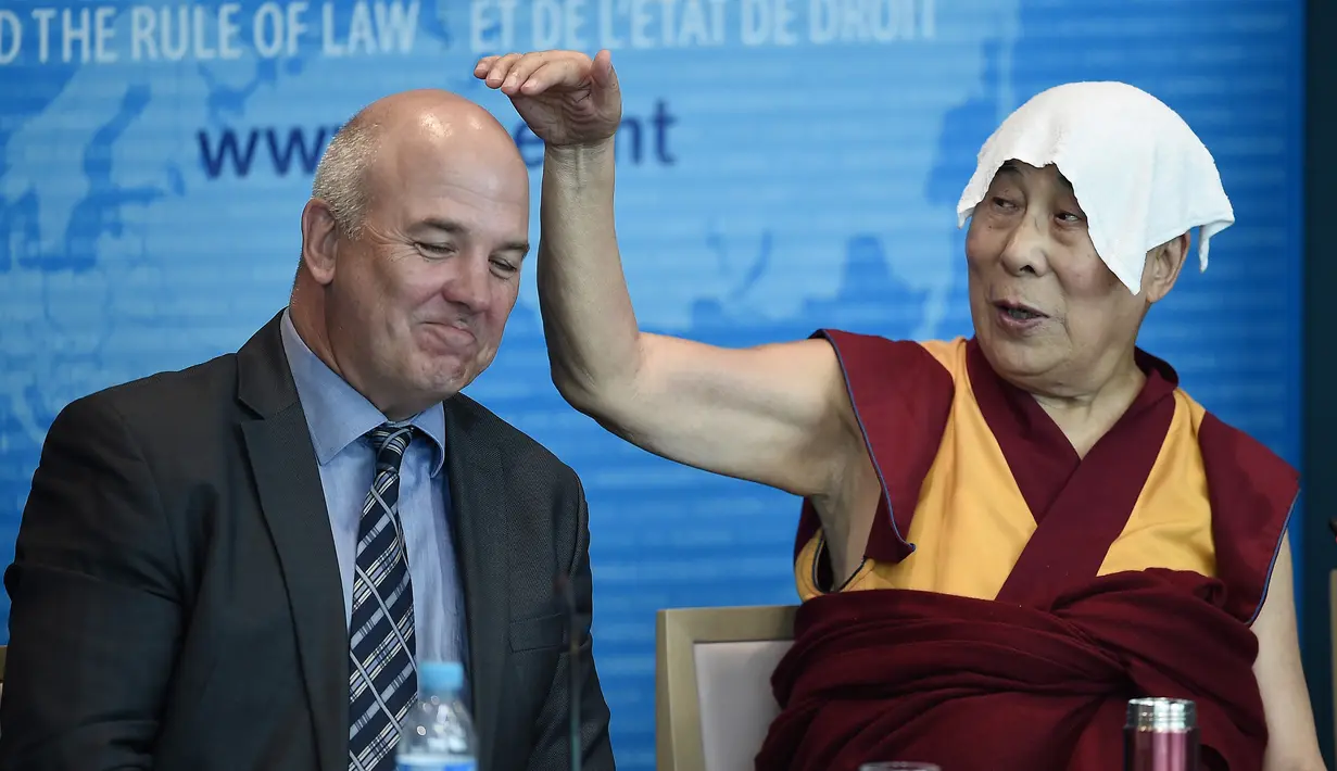 Dalai Lama menunjuk ke arah Dewan Komisaris Eropa untuk Hak Asasi Manusia, Nils Muiznieks saat ia pidato di Dewan Eropa di Strasbourg, Perancis, Kamis (15/9). Ini adalah kunjungan Eropa pertama Dalai Lama setelah lima tahun. (AFP PHOTO/Frederick Florin)