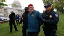 Petugas polisi mengamankan demonstran bernama Adam Eidinger saat menggelar aksinya di dekat gedung Capitol di Washington (24/4). (AP Photo/Alex Brandon)