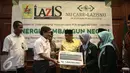 Direksi PLN Amir Rosidin mewakili Yayasan PLN memberikan Beasiswa Cahaya Pintar untuk 50 Mahasiswa Nahdhatul Ulama dalam acara penandatangan MoU di Gedung PBNU, Jakarta, Kamis (29/12). (Liputan6.com/Faizal Fanani)