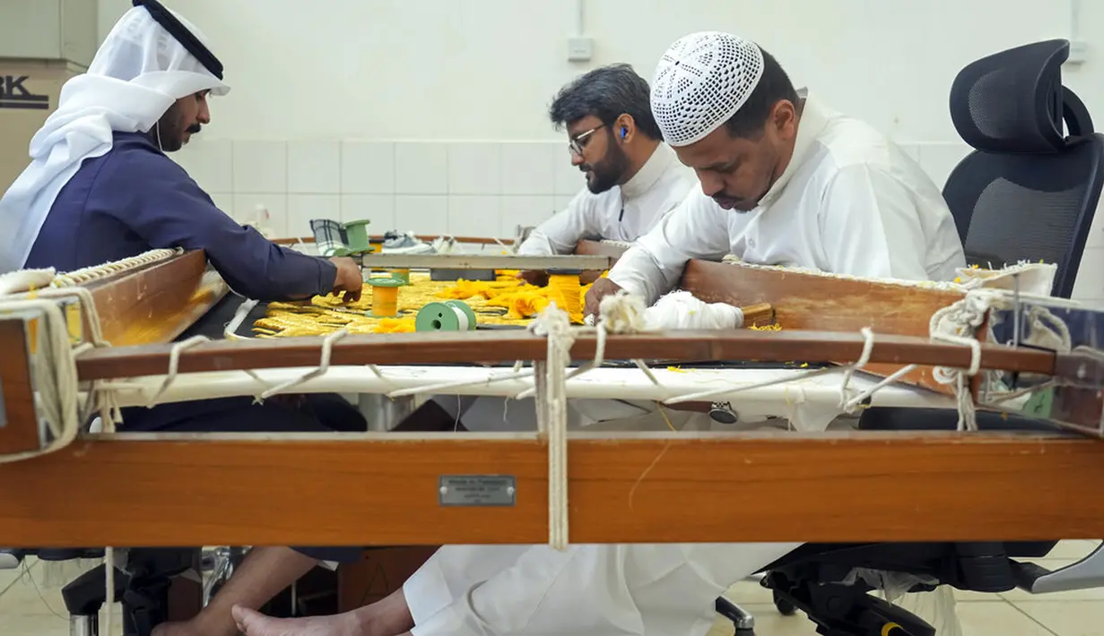 Pekerja menyulam kaligrafi Islam menggunakan benang perak murni atau benang perak berlapis emas pada tahap akhir pembuatan Kiswah Kabah di Mekah, Arab Saudi, 6 Juli 2022. Jemaah haji berkumpul di Kota Suci Mekah untuk haji terbesar sejak pandemi virus corona COVID-19. (AP Photo/Amr Nabil)