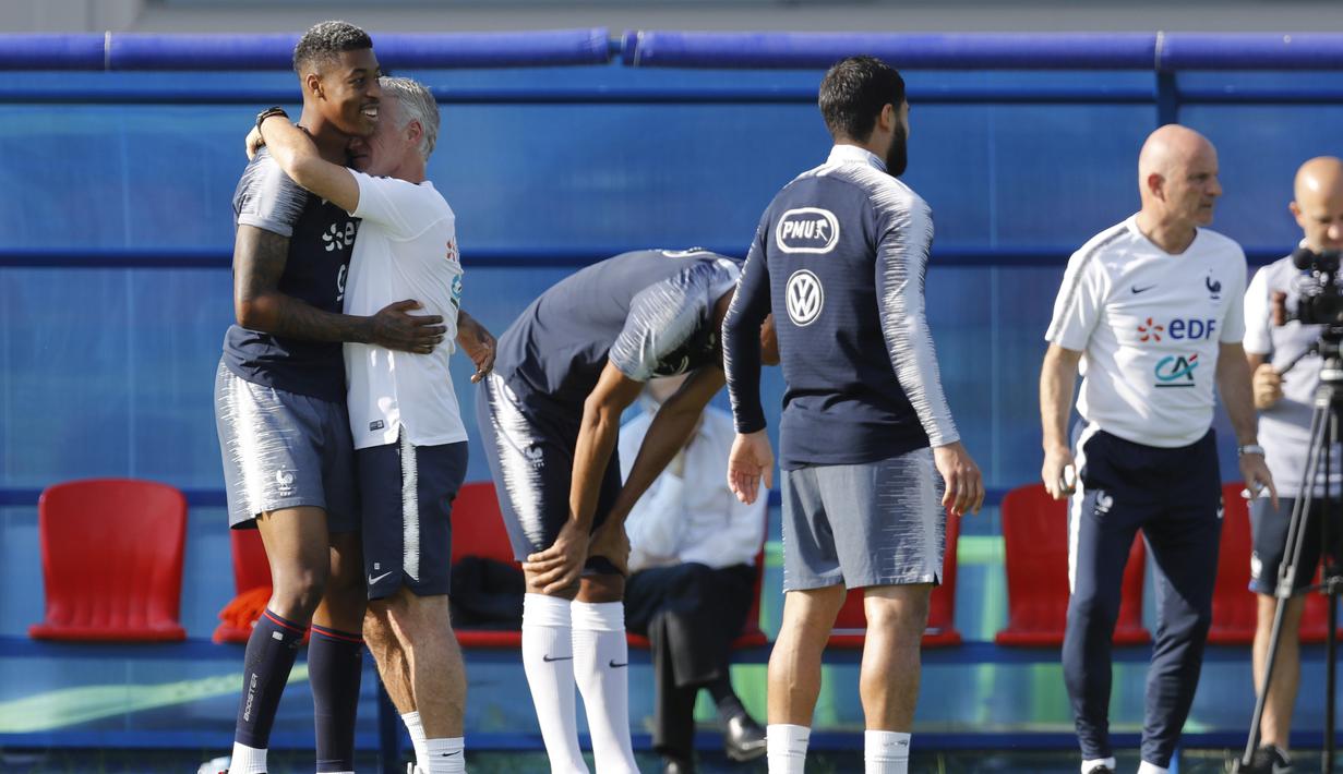 Pelukan pelatih Prancis, Didier Deschamps kepada Presnel Kimpembe saat sesi latihan di Glebovets, Rusia, (12/7/2018). Latihan tersebut sebagai persiapan Prancis melawan Kroasia pada Final Piala Dunia 2018. (AP/David Vincent)