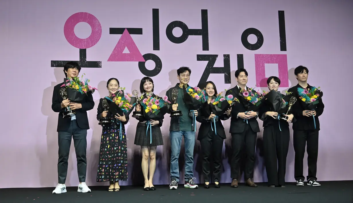 Aktris Korea Selatan Lee Yoo-mi dan Sutradara Hwang Dong-hyuk berpose dengan anggota staf serial Netflix "Squid Game" selama konferensi pers perayaan Emmy di Seoul, Korea Selatan (16/9/2022). Peraihan tersebut membuat serial asli Netflix berbahasa Korea itu menjadi program non-Inggris pertama yang pernah memenangkan penghargaan TV paling bergengsi di Amerika Serikat. (AFP/Jung Yeon-je)