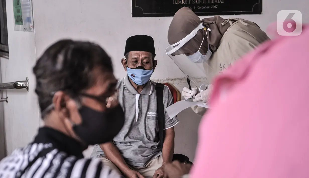 Warga lansia duduk istrahat usai mengikuti vaksin Covid-19 di Puskesmas Kecamatan Cilincing, Jakarta, Selasa (23/2/2021). Pemerintah mulai melakukan vaksinasi tahap dua yang diprioritaskan untuk masyarakat usia 60 tahun ke atas atau lansia. (merdeka.com/Iqbal S. Nugroho)