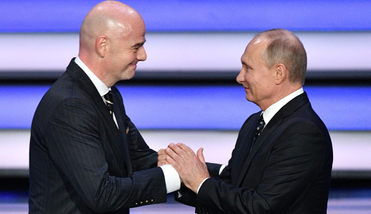 Presiden FIFA, Gianni Infantino (kiri) menyambut kehadiran presiden Rusia, Vladimir Putin saat undian Piala Dunia 2018 di State Kremlin Palace, Moscow, (1/12/2017). Piala Dunia 2018 dimulai sejak 14 Juni-15 Juli 2018 di Rusia. (AFP/Mladen Antonov)