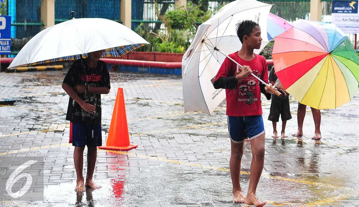 Musim hujan dimanfaatkan sejumlah anak untuk mengojek payung, Jakarta, Selasa (1/11). Musim hujan membawa berkah bagi anak-anak tersebut karena bisa mendapatkan rezeki lebih dari jasa ojek payung. (Liputan6.com/Angga Yuniar)
