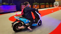 Seorang perempuan menjajaln motor listrik dalam Indonesia Electric Motor Show (IEMS) 2022 di Jakarta Convention Center, Jakarta, Kamis (29/9/2022). Dengan tema ‘Strengthening Autonomus Ecosystem’, ada sekitar 50 peserta pameran yang mengikuti pameran ini. (Liputan6.com/Johan Tallo)