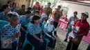 Panitia memberikan pengarahan pada penyandang disabilitas sebelum menyoblos pada Pilkada Putaran kedua di TPS 07 Kelurahan Cawang, Jakarta, Rabu (19/4). (Liputan6.com/Gempur M. Surya)