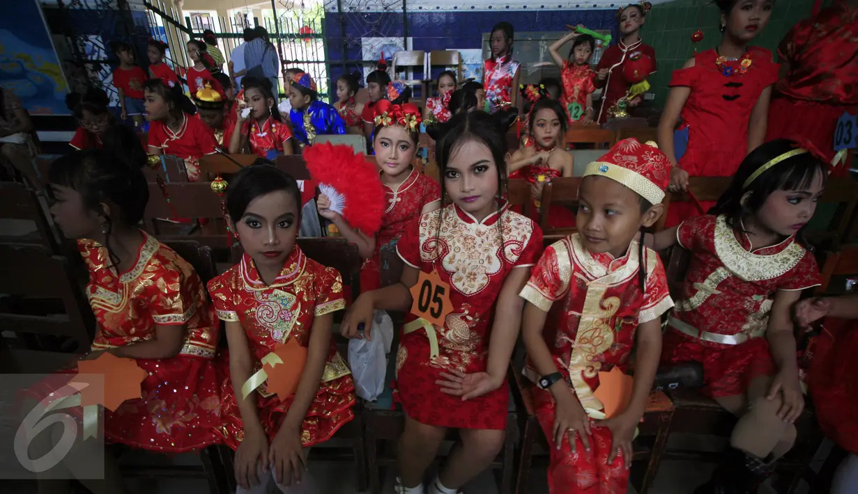 Sejumlah siswa menunggu giliran untuk memperagakan busana cheongsam saat fashion show di SD Warga, Solo, Jawa Tengah, Jumat (5/2/2016). Fashion show bernuansa tionghoa diselenggarakan untuk menyambut Tahun Baru Imlek. (Foto: Boy Harjanto)