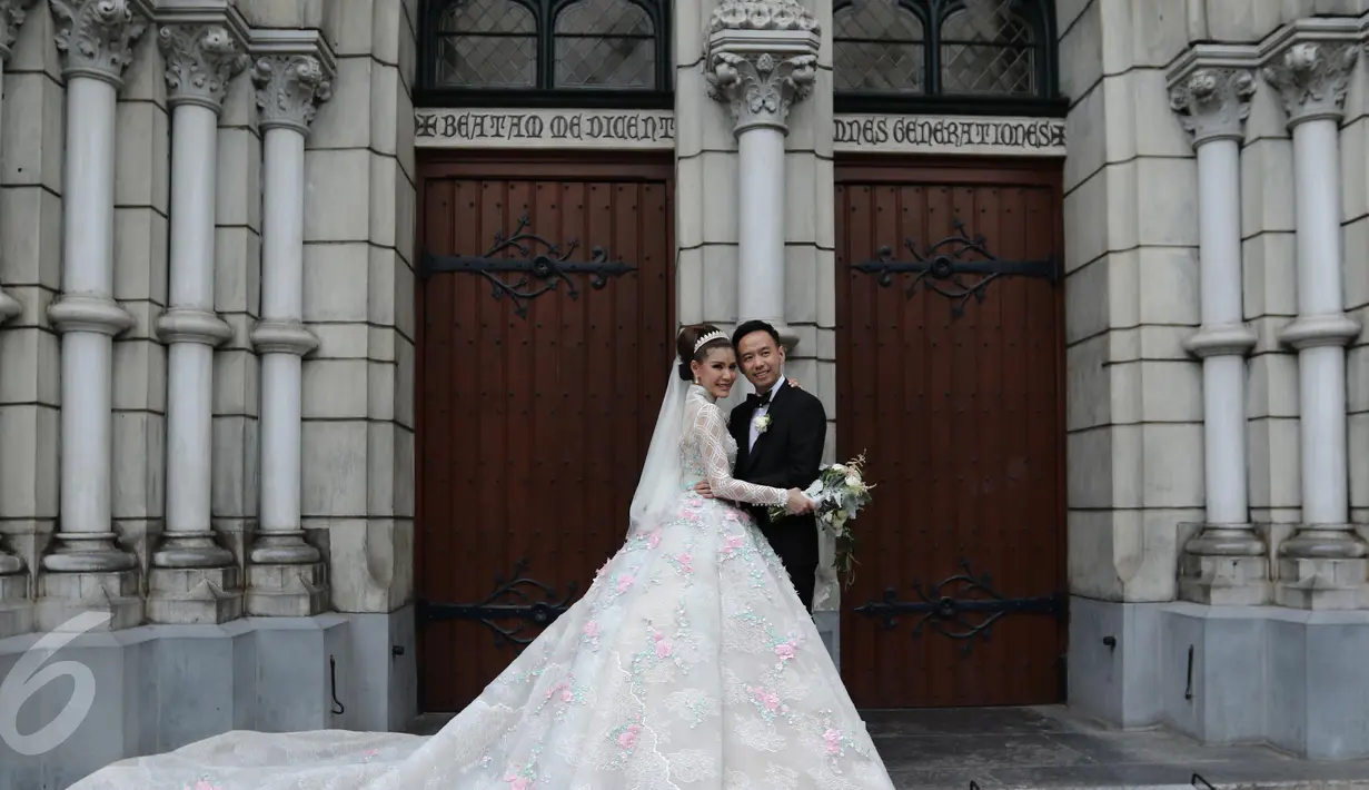 Pasangan Selebritis Olga Lydia dan Aris berpose seusai menjalankan sakramen pernikahan di Gereja Katedral, Jakarta, Jumat (21/4). Aktris Olga Lydia dan Aris Utama menjalankan sakramen pernikahan. (Liputan6.com/Herman Zakharia)