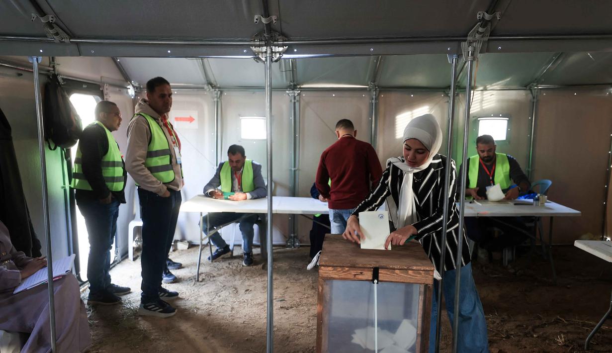 Sekitar 1,5 juta warga Palestina terdaftar untuk memberikan suara di Tepi Barat untuk memilih anggota dewan kota dan desa. Tampak dalam foto, seorang wanita Palestina memberikan suara dalam pemilihan kota di Deir el-Balah, Jalur Gaza, pada Sabtu 25 April 2026. (Eyad Baba/AFP)