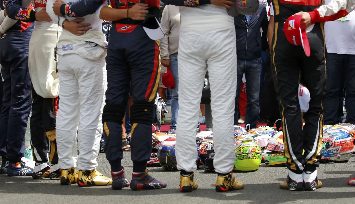 Para pebalap F1 meletakkan helm di tengah lingkaran saat mengheningkan cipta selama satu menit sebelum memulai balapan. (Reuters/Laszlo Balogh)