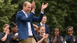 Pangeran William bereaksi sambil mengamati latihan anak-anak program pendidikan sepak bola Wildcats Girls saat mengunjungi tim sepak bola wanita Inggris, di Kensington Palace, London, Kamis (13/7). (Dominic Lipinski / POOL / AFP)