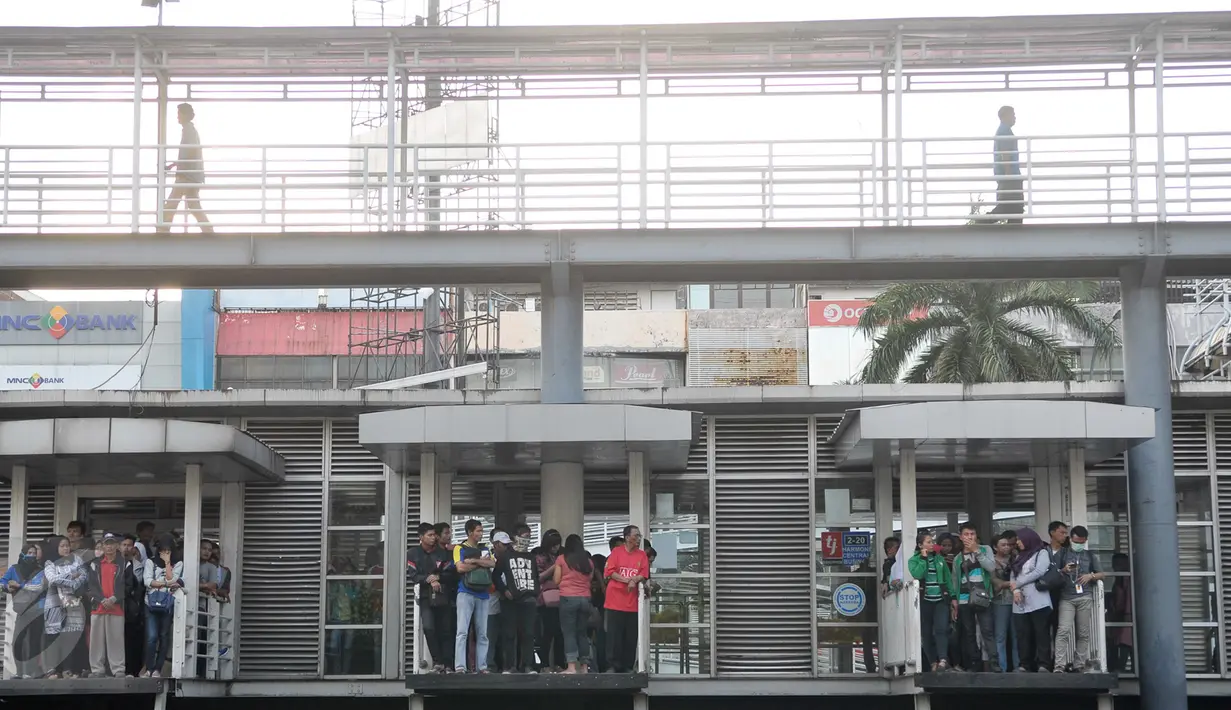 Penumpang menunggu bus Transjakarta di halte Harmoni, Jakarta, Sabtu (7/1). PT Transportasi Jakarta (Transjakarta) akan menambah 2.000 unit bus tahun 2017 ini.  (Liputan6.com/Yoppy Renato)