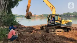 Petugas menggunakan alat berat untuk mengeruk lumpur di Setu Babakan, Jakarta, Selasa (30/6/2020). Pengerukan dilakukan guna mengembalikan kedalaman setu sehingga menambah daya tampungnya. (Liputan6.com/Immanuel Antonius)