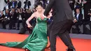 Aktris Korsel Moon So-ri kehilangan keseimbangan usai sepatu hak tingginya menginjak bagian bawah gaun yang panjang menjuntai di karpet merah pemutaran perdana film The Light Between Two Ocean di Venice Film Festival, Kamis (1/9). (FILIPPO MONTEFORTE/AFP)