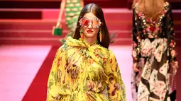 Seorang model berjalan membawa tas besar mirip tas pasar berisi sayuran untuk koleksi Dolce & Gabbana Spring/Summer 2018 pada Milan Fashion Week, Minggu (24/9). Tas pasar itu memiliki motif plaid dengan pinggiran warna kuning. (AFP PHOTO / Andreas SOLARO)