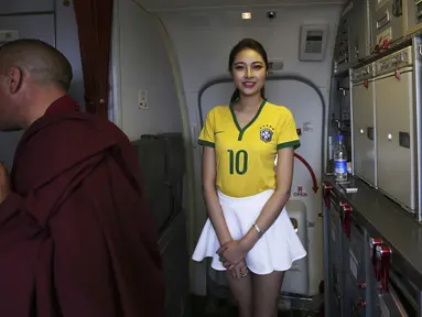 Pramugari salah satu maskapai penerbangan lokal di China mengenakan kaos bola saat bertugas, Senin (23/6/14). (REUTERS/Wong Campion)