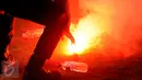 Personel kepolisian memadamkan flare yang dilempar saat laga final Piala Bhayangkara 2016 antara Arema vs Persib di Stadion GBK Jakarta, Minggu (3/4/2016). Laga diwarnai aksi protes dari suporter dan official Persib. (Liputan6.com/Helmi Fithriansyah)