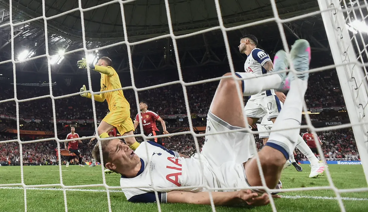 Pemain Tottenham Hotspur, Micky van de Ven terjatuh setelah menyapu bola untuk melakukan penyelamatan di depan gawang timnya dalam laga final Liga Europa 2024/2025 melawan Manchester United di Stadion San Mames, Bilbao, Spanyol, Kamis (22/05/2025) dini hari WIB. (AFP/Josep Lago)