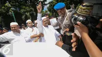 Imam Besar Front Pembela Islam (FPI), Habib Rizieq Shihab setibanya di gedung Dit Reskrimsus Polda Metro Jaya, Jakarta, Senin (23/1). (Liputan6.com/Faizal Fanani)