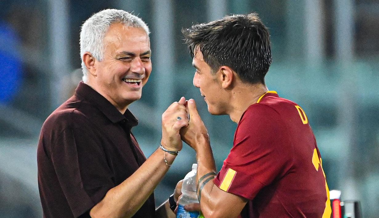 Pelatih AS Roma, Jose Mourinho (kiri) bergurau dengan pemain AS Roma, Paulo Dybala saat laga lanjutan Liga Italia melawan Monza di Olympic Stadium, Roma, Italia, 30 Agustus 2022. (AFP/Alberto Pizzoli)