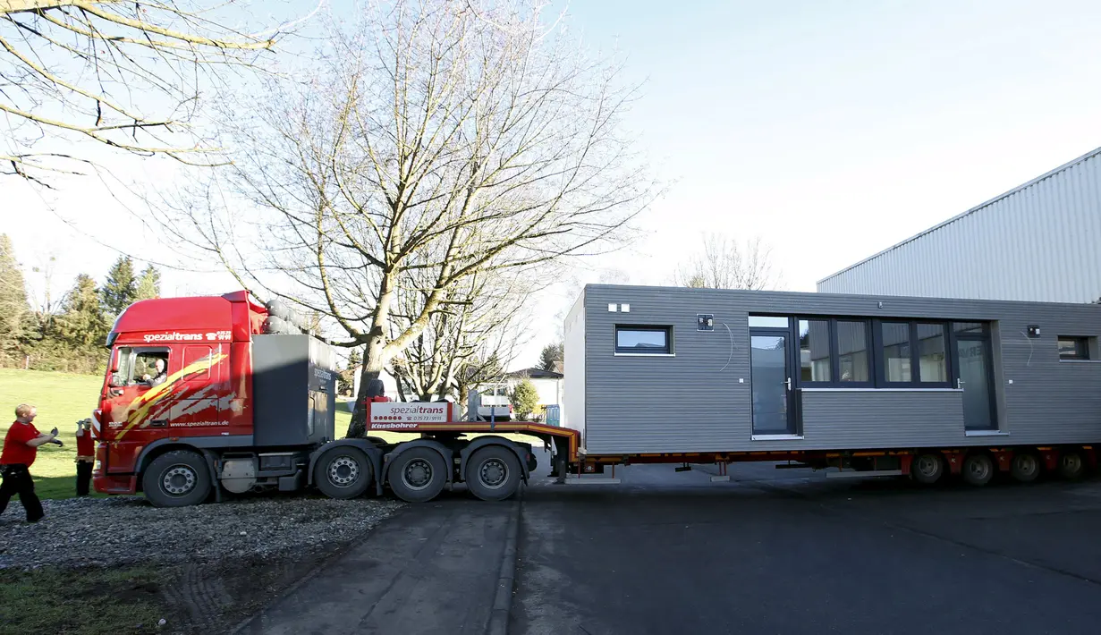 Sebuah rumah prefabrikasi saat dipindahkan dengan truk angkut di perusahaan konstruksi Bauer Holzsysteme, Jerman, (7/12). Rumah ini nantinya akan dihuni oleh para pengungsi di Jerman. (REUTERS/Michaela Rehle)
