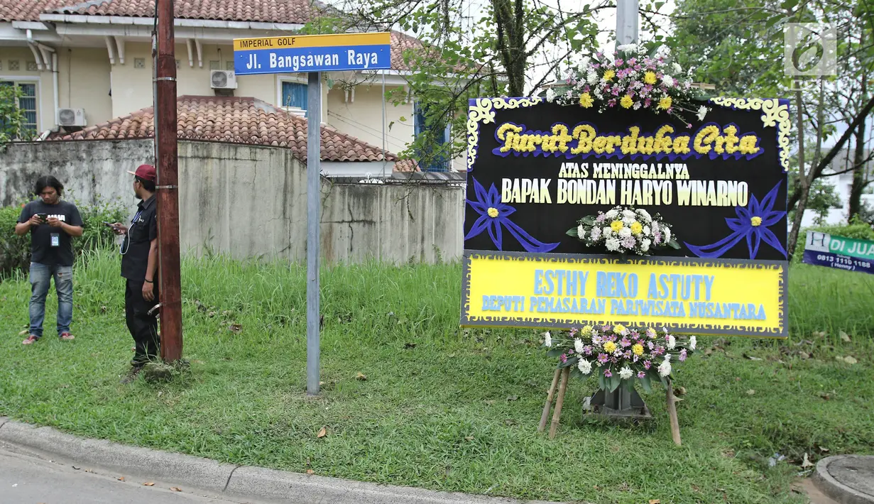 Karangan bunga duka cita diletakkan dekat kediaman pakar kuliner Bondan Winarno di kawasan Sentul, Bogor, Rabu (29/11). Jenazah Bondan Winarno sedang diberangkatkan dari RS Harapan Kita di Jakarta menuju rumah duka di Sentul (Liputan6.com/Herman Zakharia)