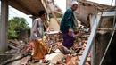 Umat muslim berjalan di atas puing-puing bangunan yang rusak akibat gempa setelah salat Jumat di Desa Gasol, Cianjur, Jawa Barat, Indonesia, Jumat (25/11/2022). Gempa dengan magnitudo 5,6 yang mengguncang Cianjur pada 21 November 2022 lalu telah menewaskan 272 orang, 2.046 orang luka-luka, dan sebanyak 62.545 orang mengungsi. (AP Photo/Achmad Ibrahim)