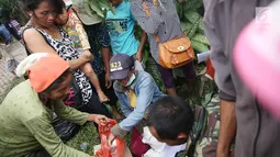 Petugas memberikan beras ke pengungsi Gunung Agung di Posko Pengungsi Rendang, Bali, Sabtu (2/12). Semakin menipisnya bahan makanan membuat warga antusias setiap kali pembagian makanan. (Liputan6.com/Immanuel Antonius)