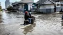 Kendaraan bermotor melintasi jalan yang tergenang air rob (banjir pasang air laut) di Kawasan Pasar Ikan Muara Baru, Jakarta, Kamis (4/6/2020). Banjir rob di Pelabuhan Muara Baru tersebut terjadi akibat cuaca ekstrem serta pasangnya air laut. (Liputan6.com/Faizal Fanani)