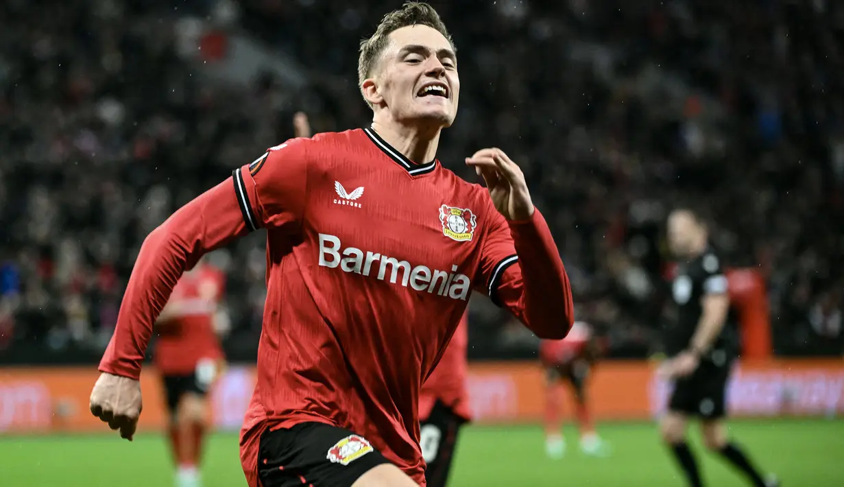 Selebrasi gelandang Bayer Leverkusen, Florian Wirtz setelah mencetak gol ke gawang Union St-Gilloise pada laga leg pertama perempatfinal Liga Europa 2022/2023 di Leverkusen (13/4/2023). Florian Wirtz sebenaranya diproyeksikan untuk menggantikan peran Riyad mahrez yang meninggalkan Manchester City untuk bermain di Liga Arab Saudi. Dengan cederanya Kevin De Bruyne dan ditinggal Riyad mahrez, mendatangkan pemain serba bisa Bayer Leverkusen, Florian Wirtz tentu jadi opsi yang realistis. (AFP/Ina Fassbender)