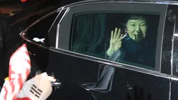 Mantan Presiden Korea Selatan (Korsel) Park Geun-hye melambaikan tangan dari dalam mobil setibanya di rumah pribadinya di Seoul, Minggu (12/3). Geun-hye meninggalkan Blue House setelah resmi dimakzulkan Mahkamah Konstitusi (MK) Korsel. (str/YONHAP/AFP)