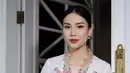 <p>Berwajah oriental, Angela tampil begitu menawan mengenakan kebaya model encim warna putih dengan aksen bordiran bunga warna-warni. [Instagram/@loritayoung_mua]</p>
