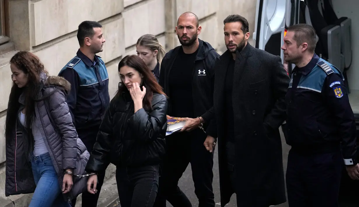 Andrew Tate (ketiga kanan) dan saudaranya Tristan (kedua kanan) dibawa dibawa oleh polisi ke Pengadilan Banding di Bukares, Rumania, Selasa (10/1/2023). Tate, Tristan, dan dua wanita Rumania yang ditahan segera menentang perpanjangan penangkapan yang diberikan kepada jaksa pada 30 Desember. (AP Photo/Vadim Ghirda)