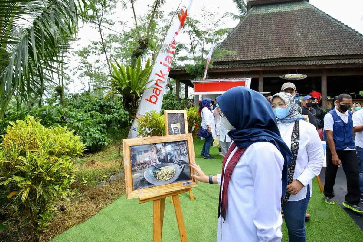 Bupati Banyuwangi Ipuk Fiestiandani  melihat foto kopi yang dipamerkan di perkebunan Kalibendo. (Istimewa)