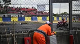 Seorang pmbalap terlihat di antara jendela marshal dalam ajang 24 Hours of Le Mans yang berlangsung di Sirkuit Bugatti, Prancis, 18 April 2026 waktu setempat. (AFP/Julien De Rosa)