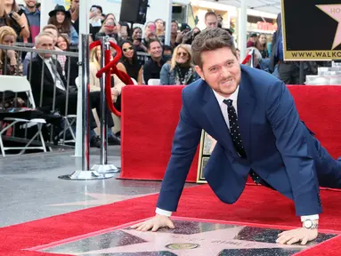 Michael Buble berpose di dekat bintang Hollywood Walk Of Fame miliknya saat acara penghargaan di Hollywood, California (16/11). Penyanyi Jazz asal Kanada ini merupakan penerima bintang ke 2,650 di Hollywood Walk Of Fame. (AFP Photo/David Livingston)