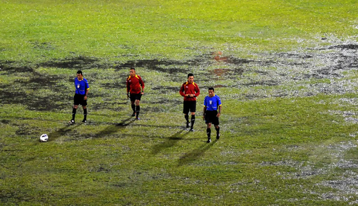 Official pertandingan mengecek kondisi lapangan stadion H Agus Salim yang tergenang air, Padang,  Sabtu (17/1/2015) . (Liputan6.com/Johan Tallo)