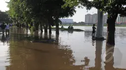 Hujan yang mengguyur Jakarta sejak Minggu (8/2) lalu, membuat Waduk Ria Rio meluap. Sejumlah warga tampak mengamati banjir yang melanda wilayah mereka di kawasan Perumahan Pulomas, Jakarta, Selasa (10/2/2015). (Liputan6.com/Herman Zakharia)