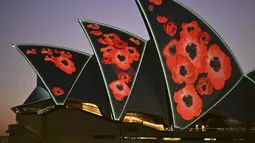 Layar Opera House diterangi dengan proyeksi bunga poppy  selama Remembrance Day Dawn Service di Sydney, Jumat (11/11/2022). Lebih dari 60.000 orang Australia tewas dalam pertempuran selama empat tahun konflik global tersebut.. (Saeed KHAN / AFP)